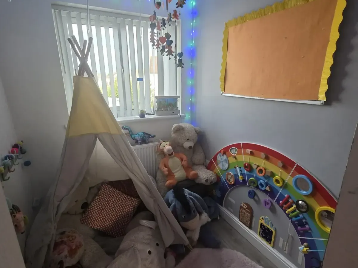Cosy sensory room with a teepee, soft toys and a rainbow activity board at Ready Steady Go Childcare Worle